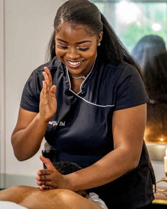 A picture of the CEO Massaging a client, while smiling.